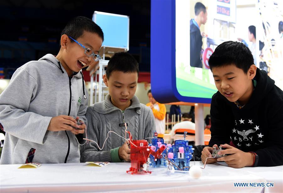 Students manipulate self-assembled robots at the Chongwen Teenager Science and Technology Museum in Dongcheng District of Beijing, capital of China, Nov. 24, 2018. China\'s primary and middle schools have been urged to improve education for all-around student development, according to a directive issued by authorities. Jointly issued by the Ministry of Education and other eight agencies, the circular asked schools to offer courses that are in accord with the national syllabus in terms of their quantity and quality. The enhancement of courses\' difficulty levels and speed at random and in disregard of the curriculum is prohibited, according to the circular. Primary and junior middle schools are not allowed to set up any \