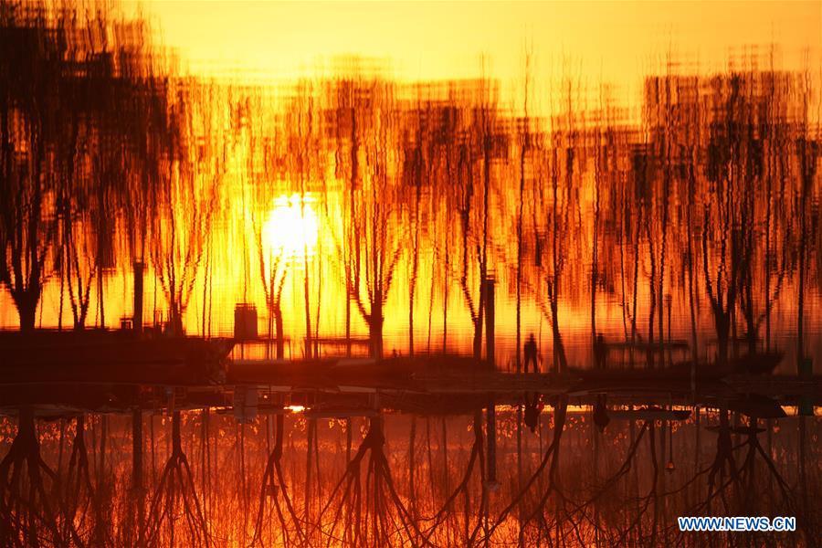 Residents do morning exercises by the Baiyangdian lake in Anxin County of Xiongan New Area, north China\'s Hebei Province, Dec. 7, 2018. China\'s central authorities have approved the 2018-2035 master plan for Xiongan New Area, stressing that its creation is significant to high-quality development and the building of the modern economic system. The plan was approved by the Central Committee of the Communist Party of China (CPC) and the State Council. The master plan is the fundamental guideline for the development, construction and management of the Xiongan New Area and should be strictly implemented, according to the approval released on Wednesday. The plan also lists overall development goals for the new area. By 2035, Xiongan will basically develop into a modern city that is green, intelligent and livable, with relatively strong competitiveness and harmonious human-environment interaction. (Xinhua/Xing Guangli)