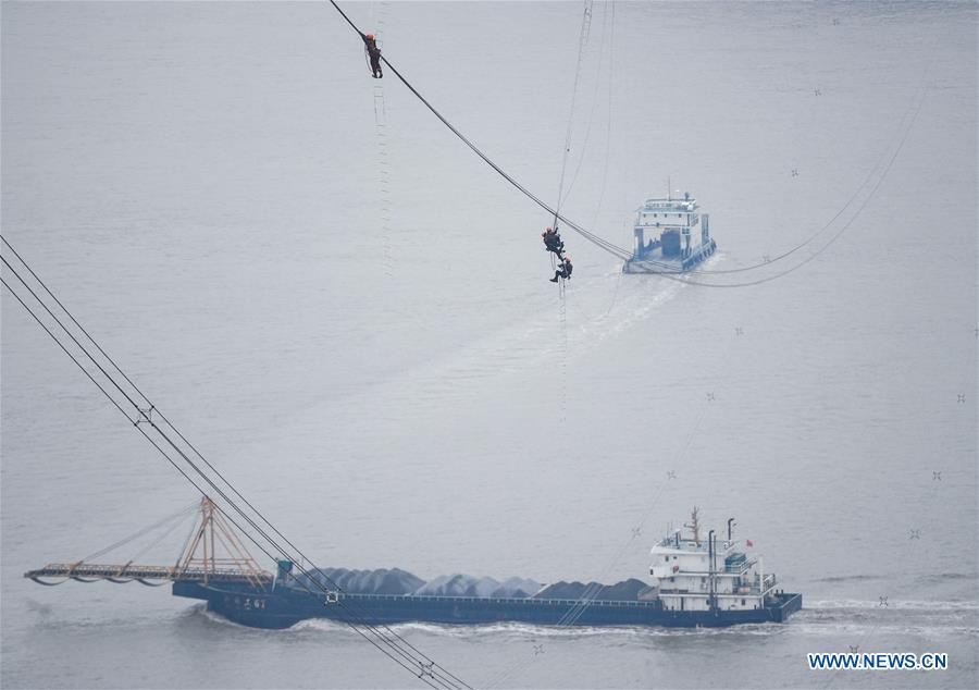 Staff members work on the cables at the site of the giant power supply pylons in Zhoushan, east China\'s Zhejiang Province, Jan. 3, 2019. The two 380-meter-tall pylons carry power cables between Zhoushan\'s Jintang and Cezi islands, a distance of 2,656 meters. The new pylon project is a part of a new ultra-high voltage power line project between cities of Zhoushan and Ningbo. (Xinhua/Xu Yu)