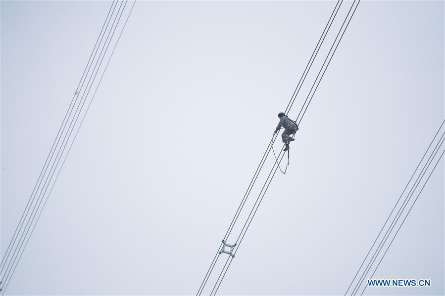 A staff member works on the cables at the site of the giant power supply pylons in Zhoushan, east China\'s Zhejiang Province, Jan. 3, 2019. The two 380-meter-tall pylons carry power cables between Zhoushan\'s Jintang and Cezi islands, a distance of 2,656 meters. The new pylon project is a part of a new ultra-high voltage power line project between cities of Zhoushan and Ningbo. (Xinhua/Xu Yu)