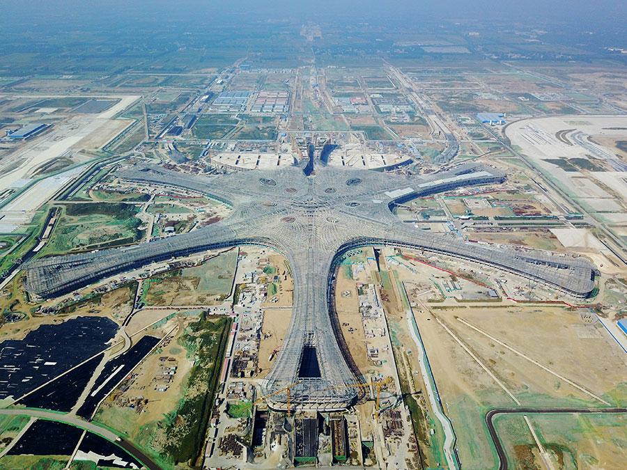 The new Beijing airport, pictured here in September, will open in 2019. (Photo/Xinhua)

The new airport, which is expected to become North China\'s air travel hub, is situated on the border of Beijing and Langfang, Hebei province. It is 46 kilometers from Tian\'anmen Square, 26 km from downtown Langfang, 55 km from the Xiongan New Area and 67 km from Beijing Capital International Airport.

Its construction adopted green and energy-saving concepts.

Zhang Ru, a representative of the airport construction headquarters, said the terminal\'s design incorporates natural light as much as possible, and many other technological innovations were used in building the integrated transportation network around the airport.

\