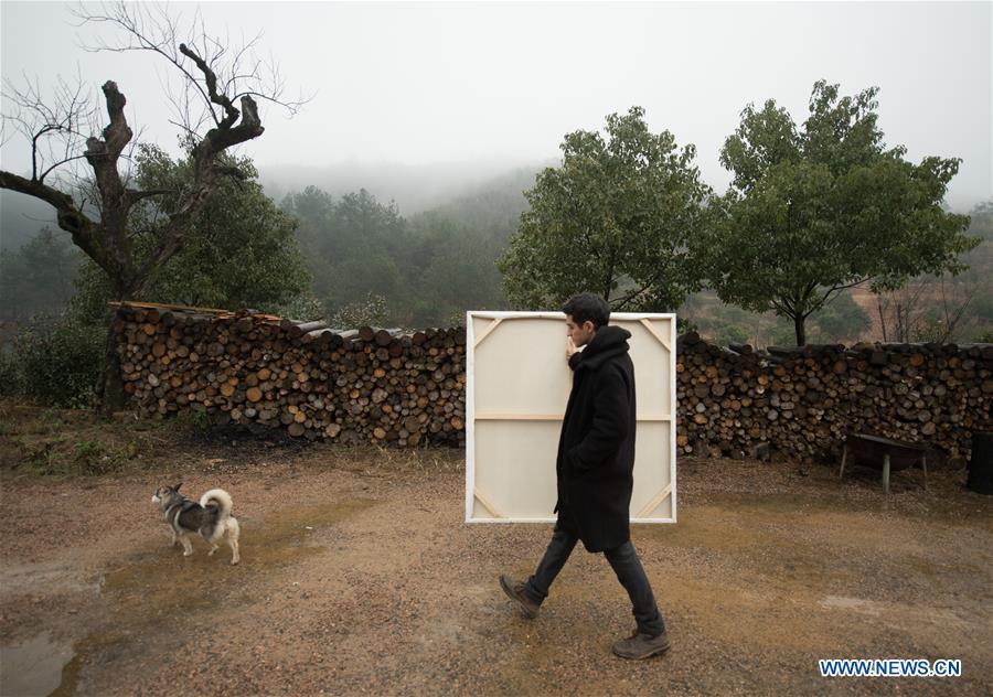 Mehraz Karami carries a painting at Shanbei Village in Daixi Town of Huzhou City, east China\'s Zhejiang Province, Jan. 7, 2019. Iranian Mehraz Karami, who was born in Tehran in 1993, has shown his interest in Chinese culture ever since his childhood. He came to Daixi Town and set up his own painting workshop at the end of 2017 after graduation from east China\'s Shanghai. He said he hoped to stay in China and become an artist. (Xinhua/Weng Xinyang)