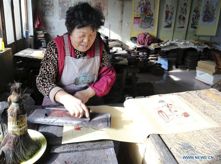 A folk artist prints woodblock New Year paintings in Yangjiabu Village of Hanting District in Weifang, east China\'s Shandong Province, Jan. 8, 2019. Local folk artists are busy making woodblock New Year paintings for the upcoming Spring Festival, which starts from the first day of the first month of the Chinese lunar calendar, or Feb. 5 this year. (Xinhua/Zhang Chi)