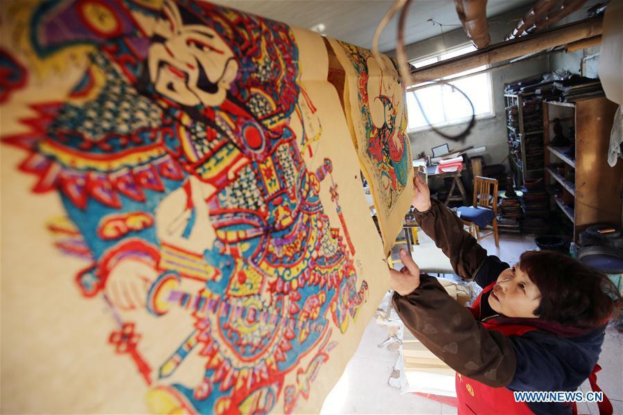 A folk artist airs woodblock New Year paintings in Yangjiabu Village of Hanting District in Weifang, east China\'s Shandong Province, Jan. 8, 2019. Local folk artists are busy making woodblock New Year paintings for the upcoming Spring Festival, which starts from the first day of the first month of the Chinese lunar calendar, or Feb. 5 this year. (Xinhua/Zhang Chi)