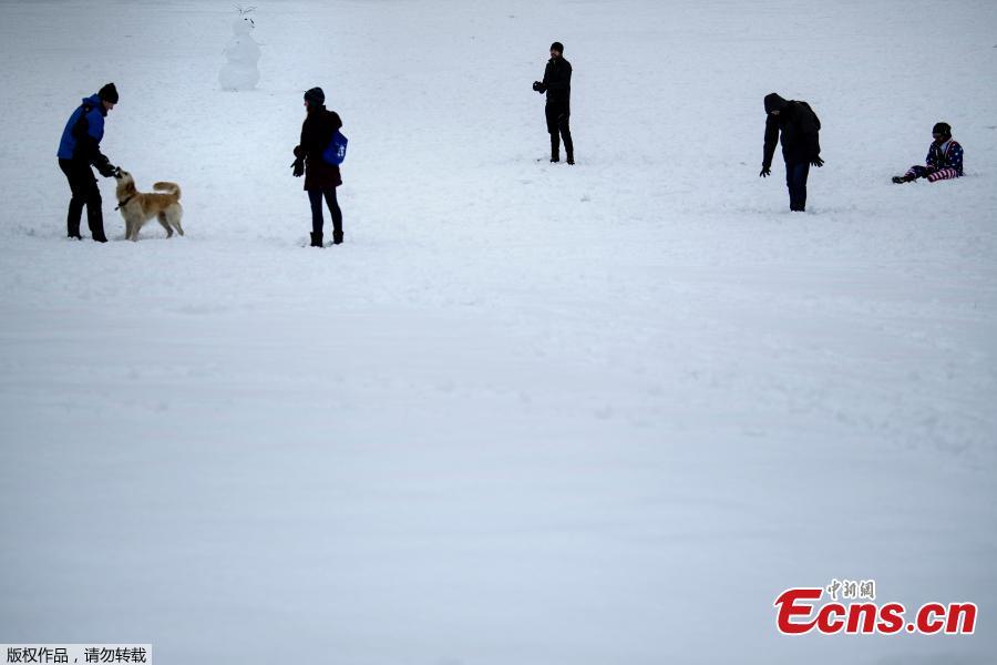 Visitors make their way through snow left by Winter Storm Gia, which paralyzed much of the midsection of the U.S., on the grounds of the Washington Monument, in Washington, DC, Jan. 13, 2019.  (Photo/Agencies)
