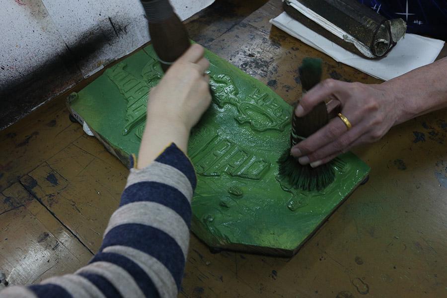 A woman is seen working on a traditional Yangliuqing woodblock printing.  (Photo/chinadaily.com.cn)