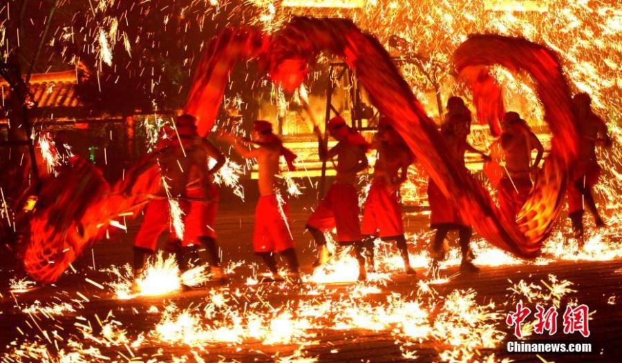 People perform a fire dragon dance in a shower of molten iron sparkling like fireworks to welcome the Spring Festival in Taierzhuang ancient town in Zaozhuang City, East China\'s Shandong Province, Jan. 13, 2019. The Spring Festival, or Chinese Lunar New Year, falls on Feb. 5 this year.  (Photo: China News Service/Yong Jun)