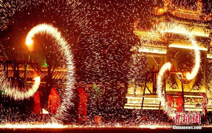 People perform a fire dragon dance in a shower of molten iron sparkling like fireworks to welcome the Spring Festival in Taierzhuang ancient town in Zaozhuang City, East China\'s Shandong Province, Jan. 13, 2019. The Spring Festival, or Chinese Lunar New Year, falls on Feb. 5 this year.  (Photo: China News Service/Yong Jun)