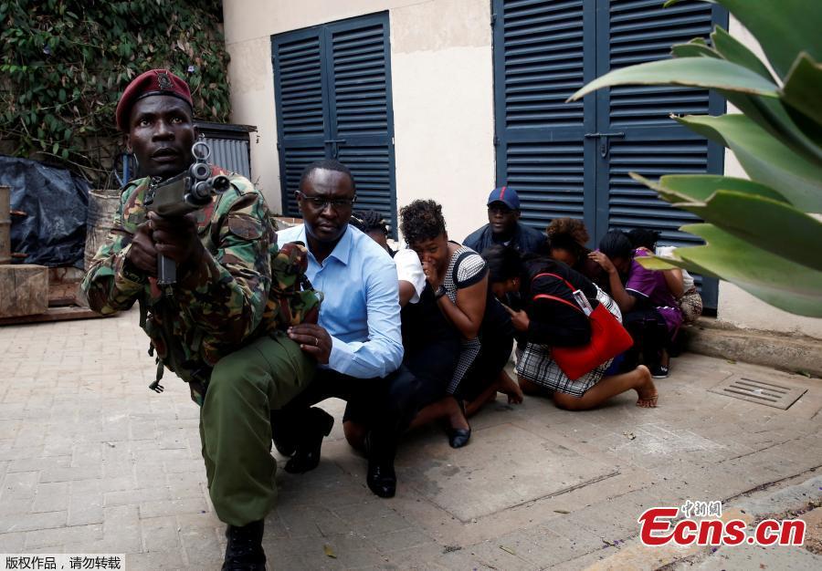 Security forces help civilians flee the scene as cars burn behind, at a hotel complex in Nairobi, Kenya Tuesday, Jan. 15, 2019. Terrorists attacked an upscale hotel complex in Kenya\'s capital Tuesday, sending people fleeing in panic as explosions and heavy gunfire reverberated through the neighborhood.  (Photo/Agencies)
