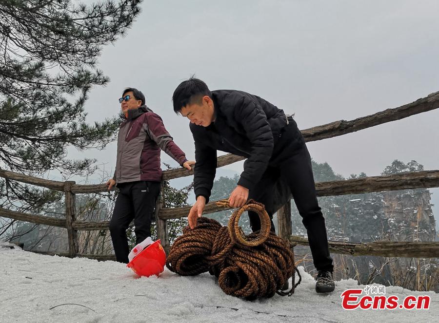 Su Songyun braves the winter cold to abseil down a cliff face and collect rubbish at the Huangshizhai scenic area in Zhangjiajie City, Central China\'s Hunan Province, Jan. 15, 2019. The 34-year-old local farmer began learning the stunt from his father in 2005, and his daredevil antics entertain tourists and enable him to collect garbage otherwise inaccessible on the mountain slope. (Photo: China News Service/Wu Yongbing)