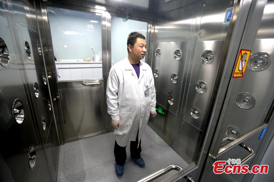 A specialist goes through a series of checks before entering a room where relics undergo restoration at the Shaanxi History Museum in Xi\'an, Northwest China\'s Shaanxi Province, Jan. 16, 2019. Visitors can view the process through a glass window. (Photo: China News Service/Zhang Yuan)