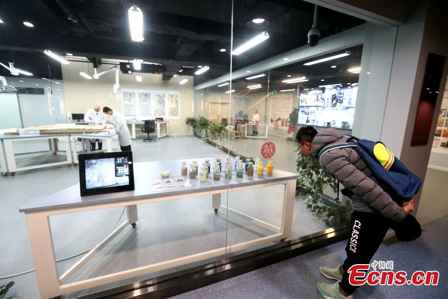 An ancient mural undergoes restoration work in a room at the Shaanxi History Museum in Xi\'an, Northwest China\'s Shaanxi Province, Jan. 16, 2019. Visitors can view the process through a glass window. (Photo: China News Service/Zhang Yuan)