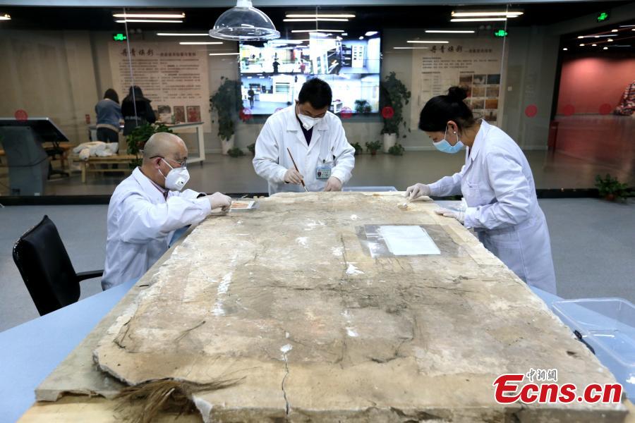 An ancient mural undergoes restoration work in a room at the Shaanxi History Museum in Xi\'an, Northwest China\'s Shaanxi Province, Jan. 16, 2019. Visitors can view the process through a glass window. (Photo: China News Service/Zhang Yuan)