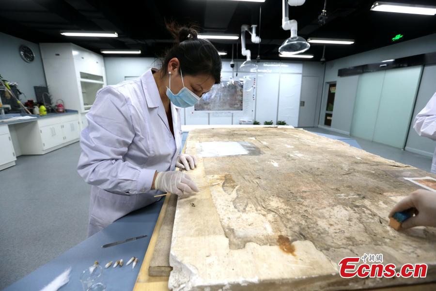 An ancient mural undergoes restoration work in a room at the Shaanxi History Museum in Xi\'an, Northwest China\'s Shaanxi Province, Jan. 16, 2019. Visitors can view the process through a glass window. (Photo: China News Service/Zhang Yuan)