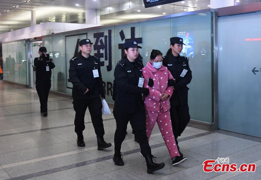 A Chinese woman suspected of illegal absorption of public deposits is escorted by police upon arrival at the Xiaoshan International Airport, Hangzhou City, Zhejiang Province, Jan. 16, 2019. The woman, the legal representative of a Hangzhou-based investment firm, was repatriated from Thailand on Wednesday. (Photo: China News Service/Wang Gang)