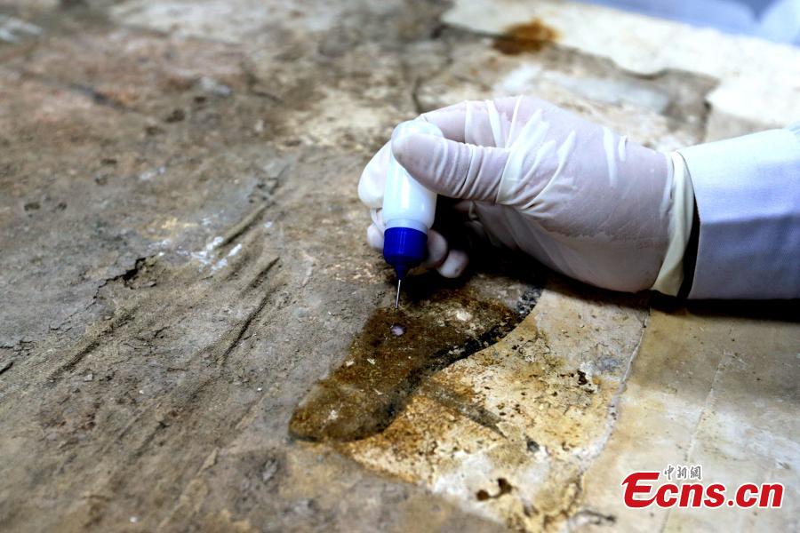 An ancient mural undergoes restoration work in a room at the Shaanxi History Museum in Xi\'an, Northwest China\'s Shaanxi Province, Jan. 16, 2019. Visitors can view the process through a glass window. (Photo: China News Service/Zhang Yuan)