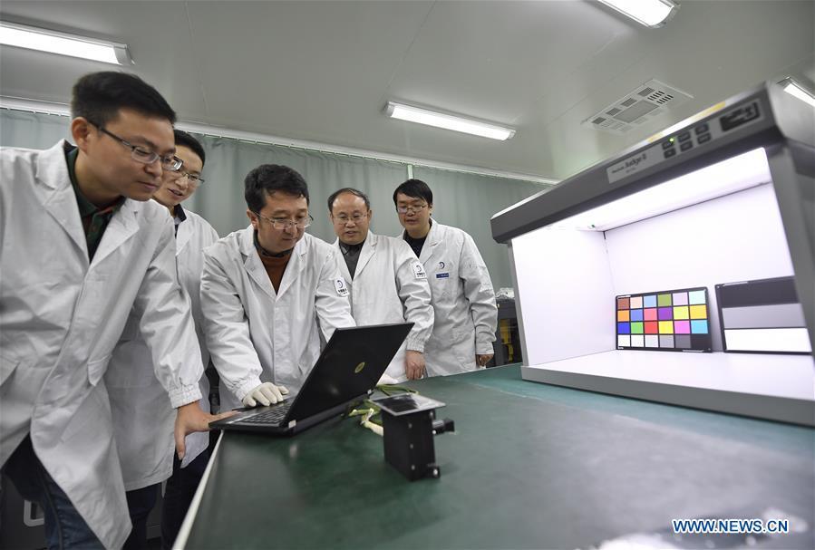 Staff members of Institute of Optics and Electronics of the Chinese Academy of Sciences examine the topographical camera installed on the lander of the Chang\'e-4 probe in Chengdu, southwest China\'s Sichuan Province, Jan. 17, 2019. The topographical camera installed on the lander of the Chang\'e-4 probe is responsible for both taking colorful high-resolution images on the lunar surface and monitoring the lunar rover Yutu-2. China\'s Chang\'e-4 lunar probe, comprising a lander and a rover, landed on the far side of the moon on Jan. 3, 2019. (Xinhua/Liu Kun)