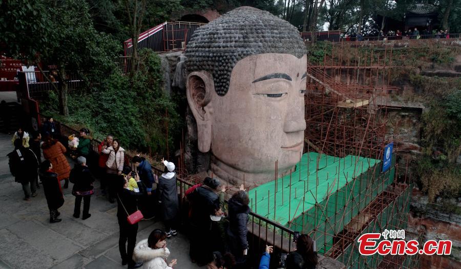 Photo taken on Jan. 17, 2019 shows the Leshan Giant Buddha statue undergoing restoration work in Leshan City, Southwest China\'s Sichuan Province. The 71-meter-tall statue, carved in the 8th century on a hillside overlooking the confluence of three rivers, is the largest Buddhist sculpture in the world. (Photo: China News Service/Liu Zhongjun)