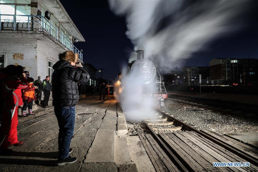 Visitors take pictures of a steam locomotive leaving Diaobingshan Station, northeast China\'s Liaoning Province on Jan. 17, 2019. A 5-day steam locomotive tourism event kicked off in Diaobingshan on Thursday. Tourists can visit the steam locomotive museum, take pictures of steam locomotives and watch exhibitions during the event. (Xinhua/Pan Yulong)