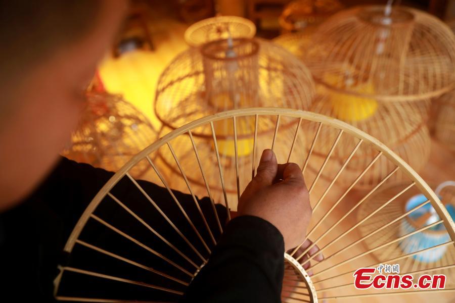 Craftsman Wang Yuhe makes a bird cage-shaped lantern, to be used in Chinese New Year celebrations, in Kala Village, Danzhai County, Southwest China\'s Guizhou Province, Jan. 17, 2019. Wang is a master of the craft, recognized as an intangible cultural heritage by the province in 2008. The village is famous for producing bird cage-shaped lanterns. (Photo: China News Service/Huang Xiaohai)