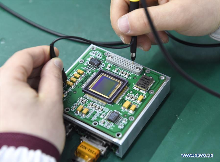 A staff member of Institute of Optics and Electronics of the Chinese Academy of Sciences examines the topographical camera installed on the lander of the Chang\'e-4 probe in Chengdu, southwest China\'s Sichuan Province, Jan. 17, 2019. The topographical camera installed on the lander of the Chang\'e-4 probe is responsible for both taking colorful high-resolution images on the lunar surface and monitoring the lunar rover Yutu-2. China\'s Chang\'e-4 lunar probe, comprising a lander and a rover, landed on the far side of the moon on Jan. 3, 2019. (Xinhua/Liu Kun)