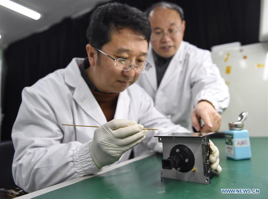 Staff members of Institute of Optics and Electronics of the Chinese Academy of Sciences examine the topographical camera installed on the lander of the Chang\'e-4 probe in Chengdu, southwest China\'s Sichuan Province, Jan. 17, 2019. The topographical camera installed on the lander of the Chang\'e-4 probe is responsible for both taking colorful high-resolution images on the lunar surface and monitoring the lunar rover Yutu-2. China\'s Chang\'e-4 lunar probe, comprising a lander and a rover, landed on the far side of the moon on Jan. 3, 2019. (Xinhua/Liu Kun)