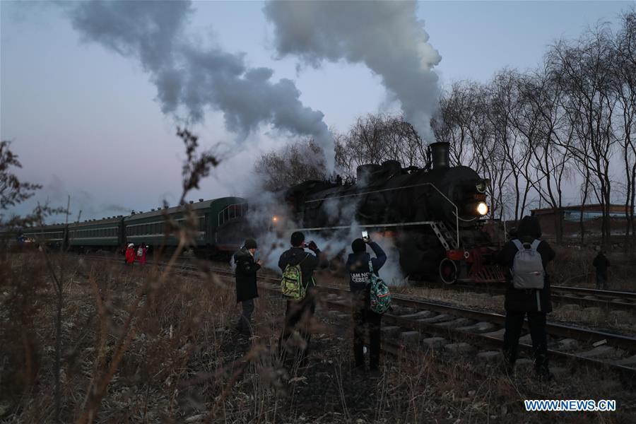 Visitors take pictures of a steam locomotive heading to the steam locomotive museum of Tiefa Energy Co., Ltd from Diaobingshan Station, northeast China\'s Liaoning Province on Jan. 17, 2019. A 5-day steam locomotive tourism event kicked off in Diaobingshan on Thursday. Tourists can visit the steam locomotive museum, take pictures of steam locomotives and watch exhibitions during the event. (Xinhua/Pan Yulong)