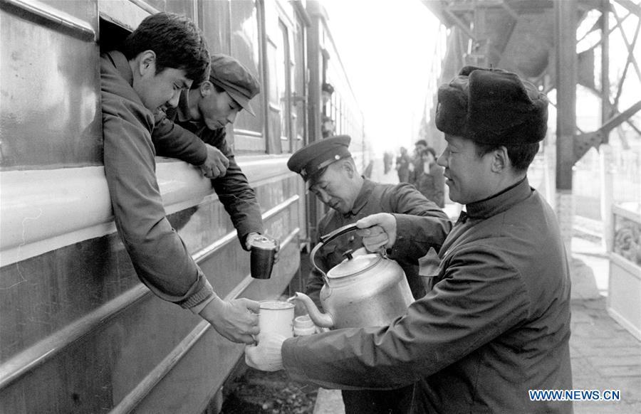 Staff members of the Shijiazhuang Railway Station pour hot water into passengers\' cups during the Spring Festival travel rush in Shijiazhuang, north China\'s Hebei Province, in the year of 1984. Returning to hometowns remains the most important part of the Chinese Spring Festival. Whether self-driving, or taking the trains or flights, homecomings and family gatherings are a priority for many Chinese. The annual travel rush around the festival, known as \
