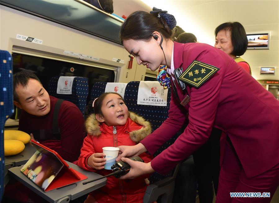 Train conductor Liao Hui (R) with Fuzhou sector of Nanchang\'s Railway Bureau brings hot water to passengers during the Spring Festival travel rush on Feb. 6, 2016. Returning to hometowns remains the most important part of the Chinese Spring Festival. Whether self-driving, or taking the trains or flights, homecomings and family gatherings are a priority for many Chinese. The annual travel rush around the festival, known as \