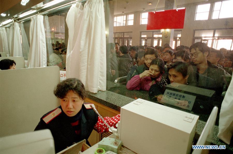Ticket seller Bai Ziping works at the Beijing Railway Station in Beijing, capital of China, Jan. 18, 1997. Returning to hometowns remains the most important part of the Chinese Spring Festival. Whether self-driving, or taking the trains or flights, homecomings and family gatherings are a priority for many Chinese. The annual travel rush around the festival, known as \
