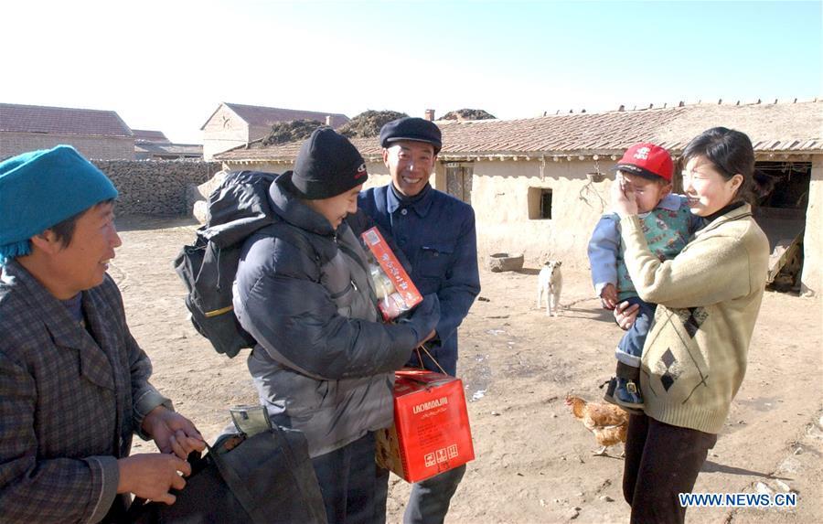 Migrant worker Chu Mingdong (2nd, L) is received by his family as he returns home for the Spring Festival family reunion in Mijiagou Village, Zhangbei County of north China\'s Hebei Province, Feb. 10, 2002. Returning to hometowns remains the most important part of the Chinese Spring Festival. Whether self-driving, or taking the trains or flights, homecomings and family gatherings are a priority for many Chinese. The annual travel rush around the festival, known as \