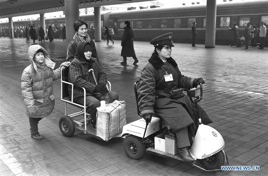 Staff member Xu Xin sends senior passenger Zhou Fengying to her train at the Beijing Railway Station in Beijing, capital of China, Jan. 30, 1994. Returning to hometowns remains the most important part of the Chinese Spring Festival. Whether self-driving, or taking the trains or flights, homecomings and family gatherings are a priority for many Chinese. The annual travel rush around the festival, known as \
