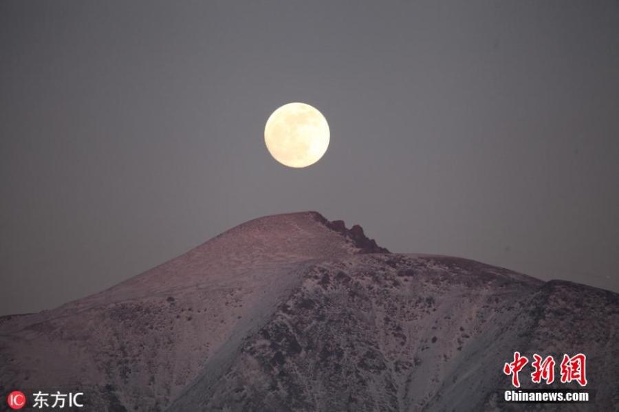 The first full moon of the new year is seen above the Tianshan Mountains in Xinjiang Uygur Autonomous Region, Jan. 20, 2019. (Photo/IC)