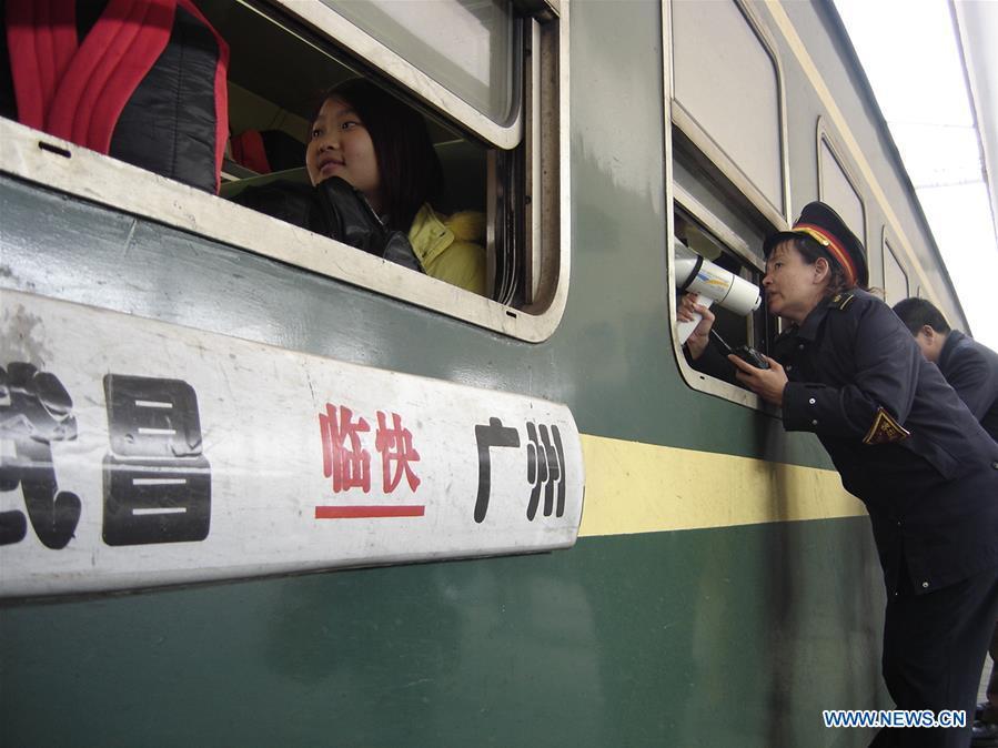 Staff members guide passengers at the Guangzhou Railway Station, south China\'s Guangdong Province, on Jan. 24, 2006. Returning to hometowns remains the most important part of the Chinese Spring Festival. Whether self-driving, or taking the trains or flights, homecomings and family gatherings are a priority for many Chinese. The annual travel rush around the festival, known as \