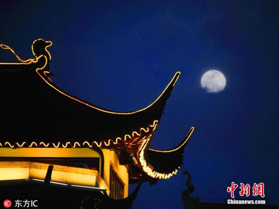 The first full moon of the new year appears beside a building in Yuyuan Garden, Shanghai, Jan. 20, 2019. (Photo/IC)