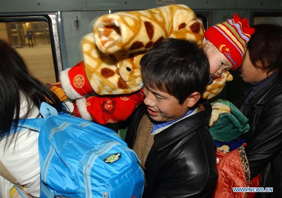 A passenger carrying his child on shoulder gets on a special train for migrant workers at the Beijing West Railway Station in Beijing, capital of China, Jan. 14, 2005. Returning to hometowns remains the most important part of the Chinese Spring Festival. Whether self-driving, or taking the trains or flights, homecomings and family gatherings are a priority for many Chinese. The annual travel rush around the festival, known as \