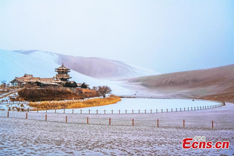 The Crescent Spring and Singing-Sand Dunes scenic spot in Dunhuang City, Northwest China\'s Gansu Province, after its first snow of the year, Jan. 19, 2019. Riding a camel across the desert landscape has become a popular activity for tourists to the area. (Photo: China News Service/Wang Binyin)