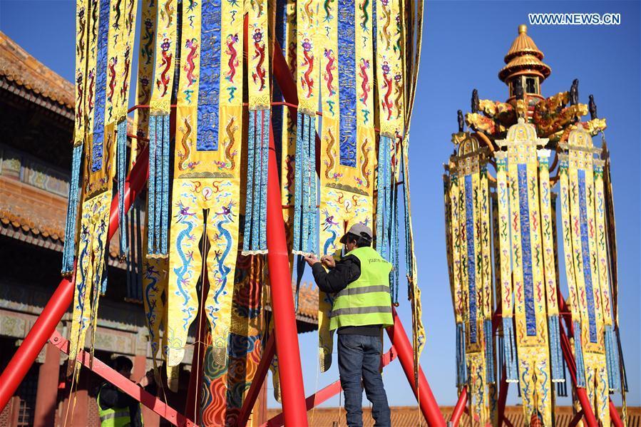 A worker stabilizes longevity lanterns installed before the Qianqing Gong, or the Palace of Heavenly Purity, at the Palace Museum, also known as the Forbidden City, in Beijing, capital of China, Jan. 21, 2019. The traditional lanterns recovered by the Palace Museum in accordance with historical archives from the Qing Dynasty (1644-1911) are opened to the public Monday, as a part of the exhibition of \