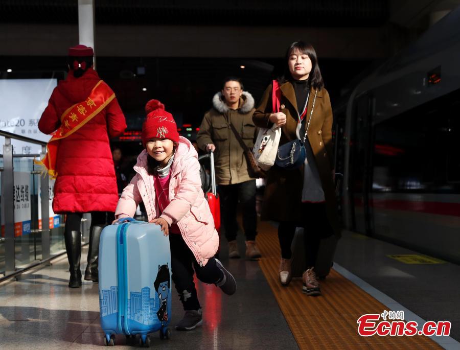 Passengers board a high-speed train at a railway station in Beijing, Jan. 21, 2019. (Photo: China News Service/Liu Guanguan)
