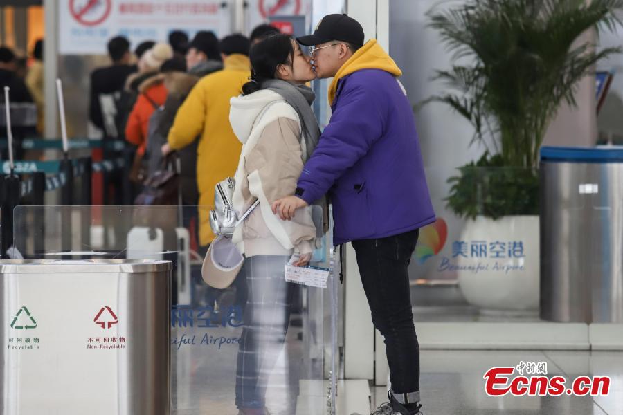 A couple kisses goodbye at Longdongbao International Airport in Guiyang City, Guizhou Province.  (Photo: China News Service/Qu Honglun)