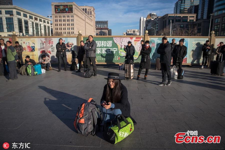 A woman waits to board a train at a railway station in Beijing. (Photo/IC)

The Spring Festival travel rush started on Jan. 21, unleashing China\'s largest seasonal migration as families reunite for their most important traditional holiday. From Jan. 21 to March 1, nearly three billion trips will be made on China\'s transport system as people set off for family gatherings or tours. These photos captured some moments in the lives of travelers across China.