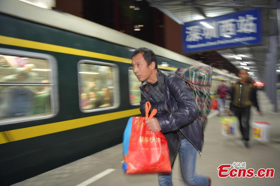 A passenger rushes to board a train at a railway station in Shenzhen City, Guangdong Province. (Photo: China News Service/Chen Wen)