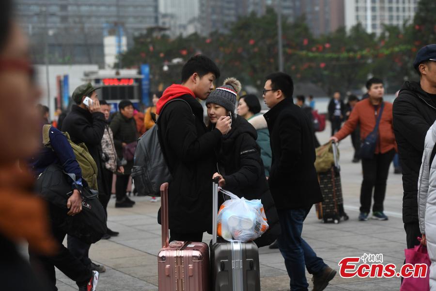 A student couple hugs each other at a railway station in Chongqing. (Photo: China News Service/Chen Chao)