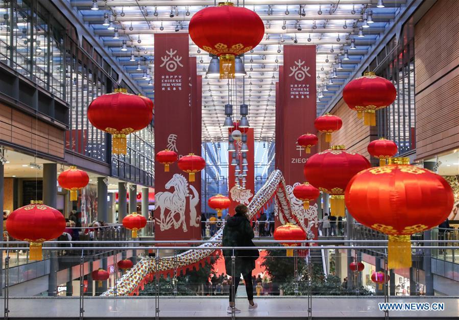 A woman walks past traditional Chinese decorations in a shopping mall at Potsdamer Platz in Berlin, capital of Germany, on Jan. 24, 2019. \