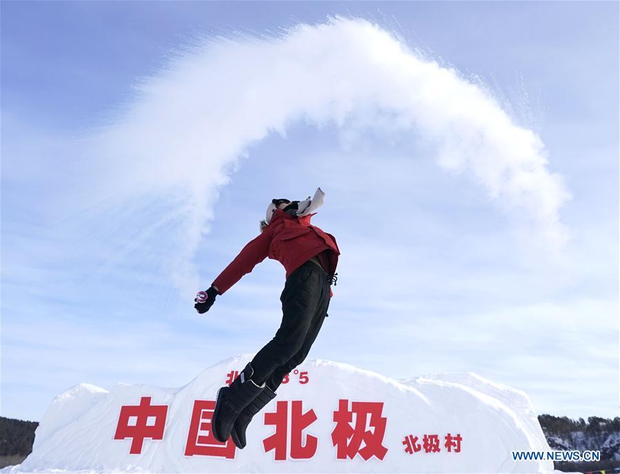 A visitor plays a game with water spray in Beiji Village, Mohe City of northeast China\'s Heilongjiang Province, Jan. 24, 2019. With the lowest temperature approaching minus 30 degrees celsius, visitors in Mohe Village experienced the game of \