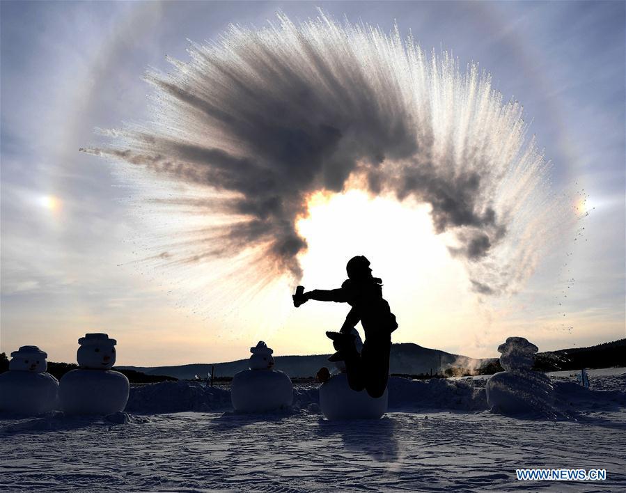 A visitor creates an ice halo with water spray in Beiji Village, Mohe City of northeast China\'s Heilongjiang Province, Jan. 24, 2019. With the lowest temperature approaching minus 30 degrees celsius, visitors in Mohe Village experienced the game of \
