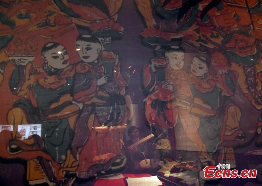 Visitors watch a performance during an exhibition of Spring Festival paintings held at Lao She Tea house in Beijing, Jan. 27, 2019. The exhibition, organized by the Ministry of Culture and Tourism and Prince Gong\'s Mansion, presented representative traditional paintings of the Lunar New Year from across the country, and will run from Jan. 28 to Feb. 28. (Photo: China News Service/Hou Yu)