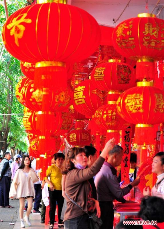 People select lunar new year decorations at a street market in Lingshui Li Autonomous County, south China\'s Hainan Province, Jan. 26, 2019. People across China are busy preparing for the upcoming Chinese Lunar New Year, which falls on Feb. 5 this year. (Xinhua/Liu Shuting)