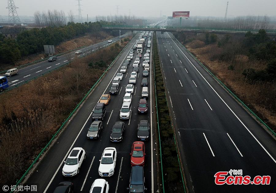 An aerial photo shows heavy traffic heading in one direction on an expressway while, in comparison, the opposite side of the road remains almost empty in Anhui Province. China is in the midst of its Spring Festival travel rush as millions of people go home for family reunions for the most important festival of the year. (Photo/VCG)