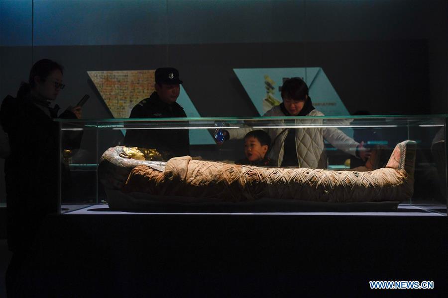 People look at a mummy displayed in an exhibition of ancient Egyptian civilization at Zhejiang West Lake Gallery in Hangzhou, capital of east China\'s Zhejiang Province, Jan. 30, 2019. A total of 180 cultural relics from Italian museums are displayed in an exhibition of ancient Egyptian civilization from Jan. 22 to May 5, 2019. (Xinhua/Huang Zongzhi)